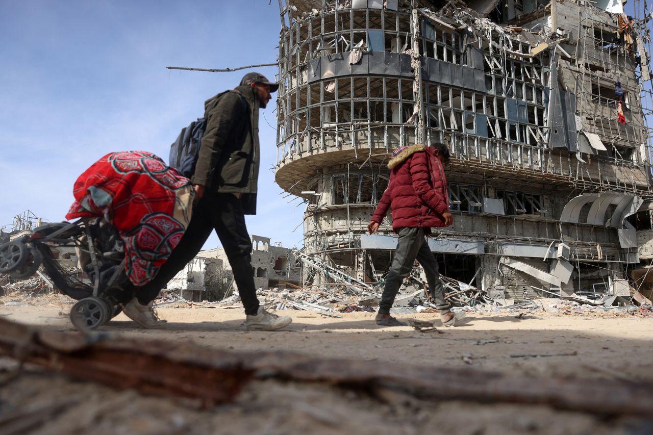 Displaced Palestinians carry their belongings as they walk amid the devastation upon their return to central Rafah on Sunday.