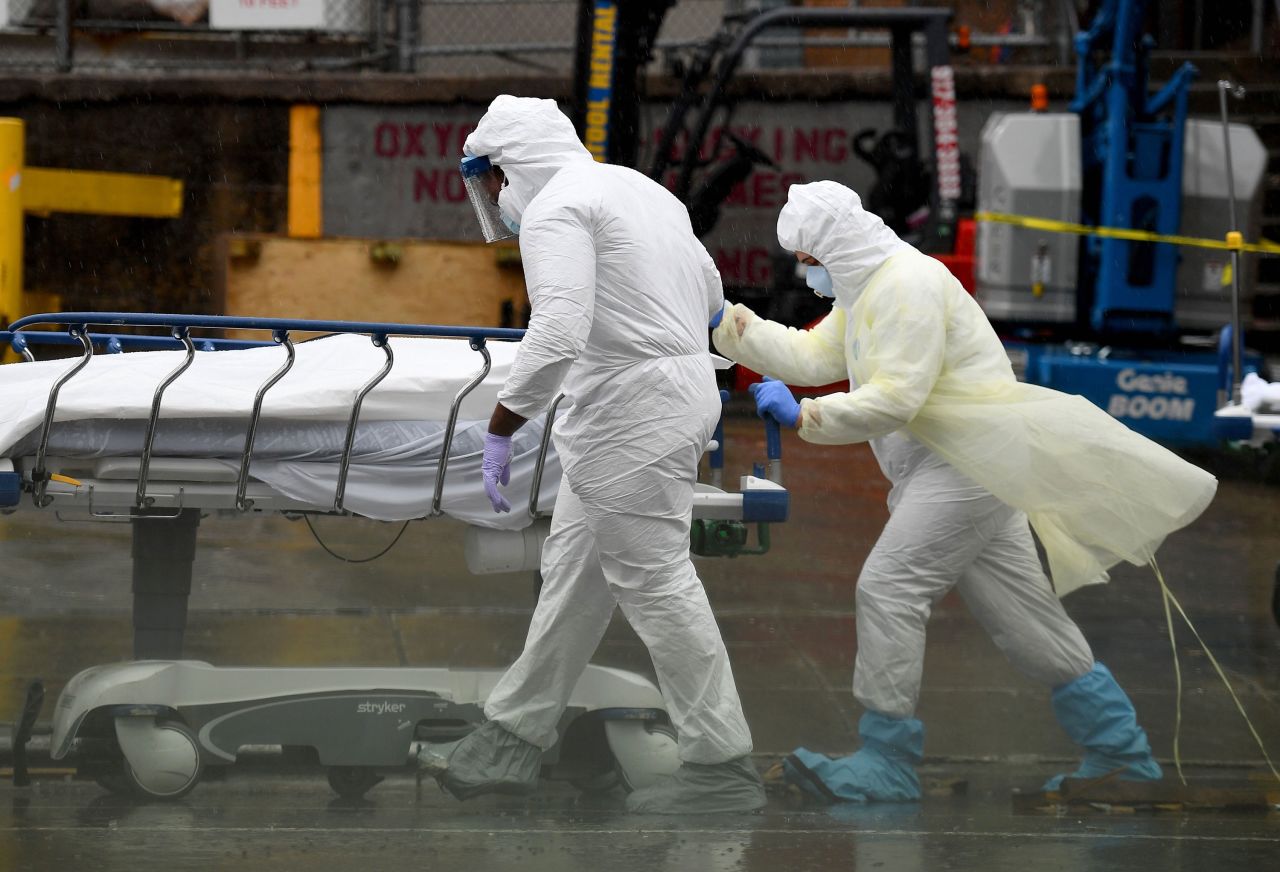 Medical personnel move a deceased patient to a refrigerated truck serving as a make shift morgue at Brooklyn Hospital Center in New York City on April 9. 