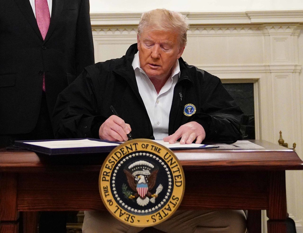 President Donald Trump signs an emergency funding bill to combat the coronavirus outbreak on Friday.