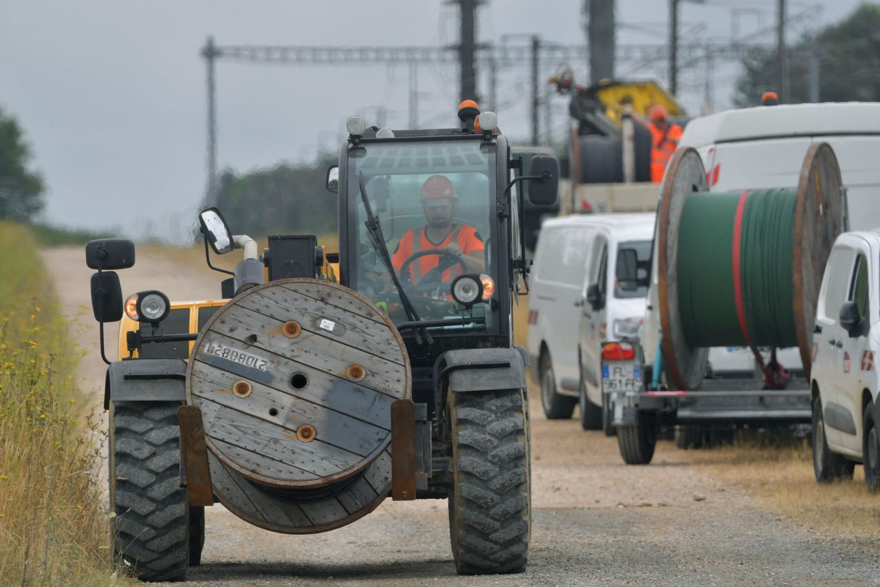 A worker transports a reel with cable to replace damaged rail cable lines in Vald' Yerres, France, on July 26. 