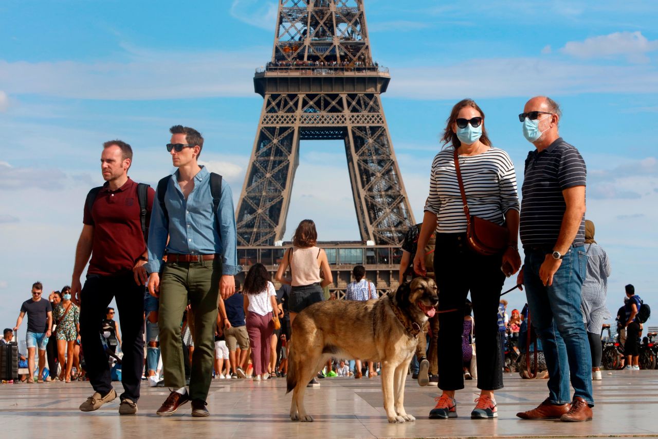 Tourists wear protective masks while visiting the Eiffel Tower on August 2 in Paris, France.