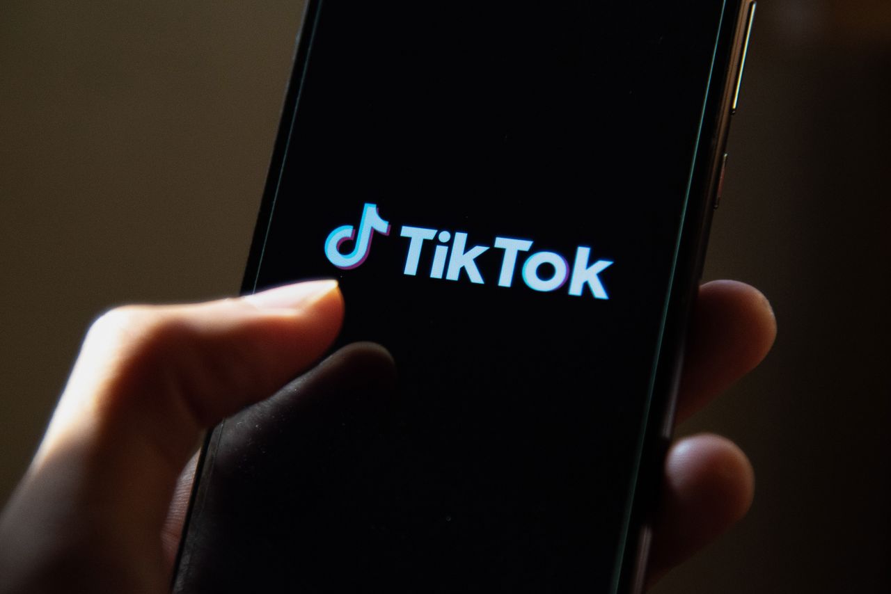 A TikTok logo is seen displayed on a smartphone screen. 