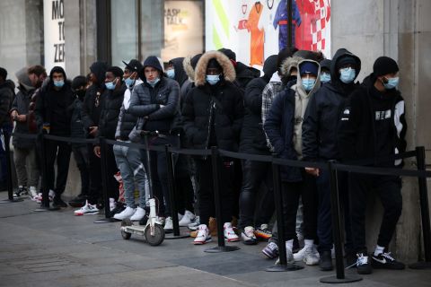 People queue outside Nike Town on Oxford Street in London, as shops reopen following coronavirus restrictions easing on April 12. 