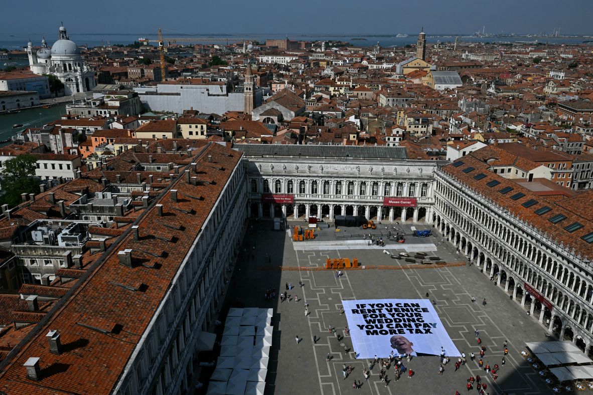 Activists of the international environmental group Greenpeace deploy a giant banner at St. Mark Square in Venice, Italy, on Monday, June 23. It reads, "If you can rent Venice for your wedding you can pay more tax." Amazon founder Jeff Bezos and former journalist Lauren Sanchez <a  target="_top" href="/newspapers?url=https://www.cnn.com/2025/06/25/style/gallery/venice-wedding-jeff-bezos-lauren-sanchez">are getting married in Venice</a> this week.
