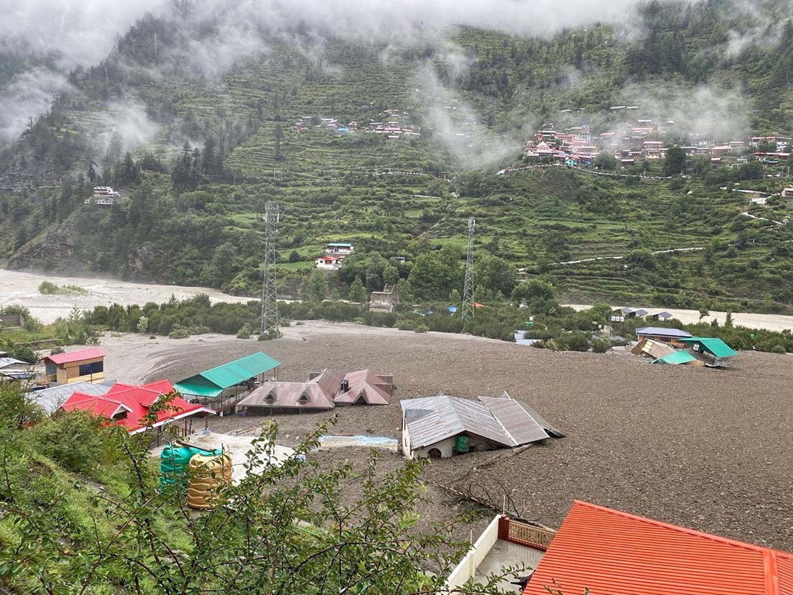 Houses are partially buried by a mudslide amid <a href="index.php?page=&url=https%3A%2F%2Fwww.cnn.com%2F2025%2F08%2F05%2Fweather%2Findia-flooding-dharali-climate">flash floods</a> in Dharali, India, on Tuesday, August 5. A surge of flood water tore through the mountainous village, leaving at least four people dead and dozens missing, officials said.
