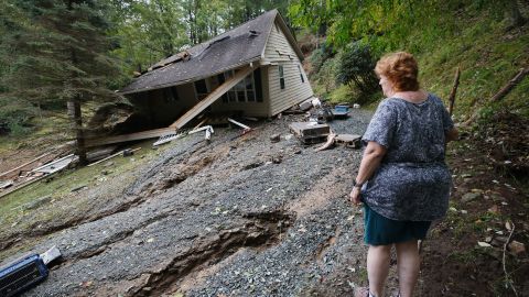 Meta Gatschenberger surveys the remains of her collapsed and destroyed house shortly after she and her husband arrived back in the area in the aftermath of Tropical Storm Helene, in Boone, North Carolina, U.S. September 28, 2024.  REUTERS/Jonathan Drake