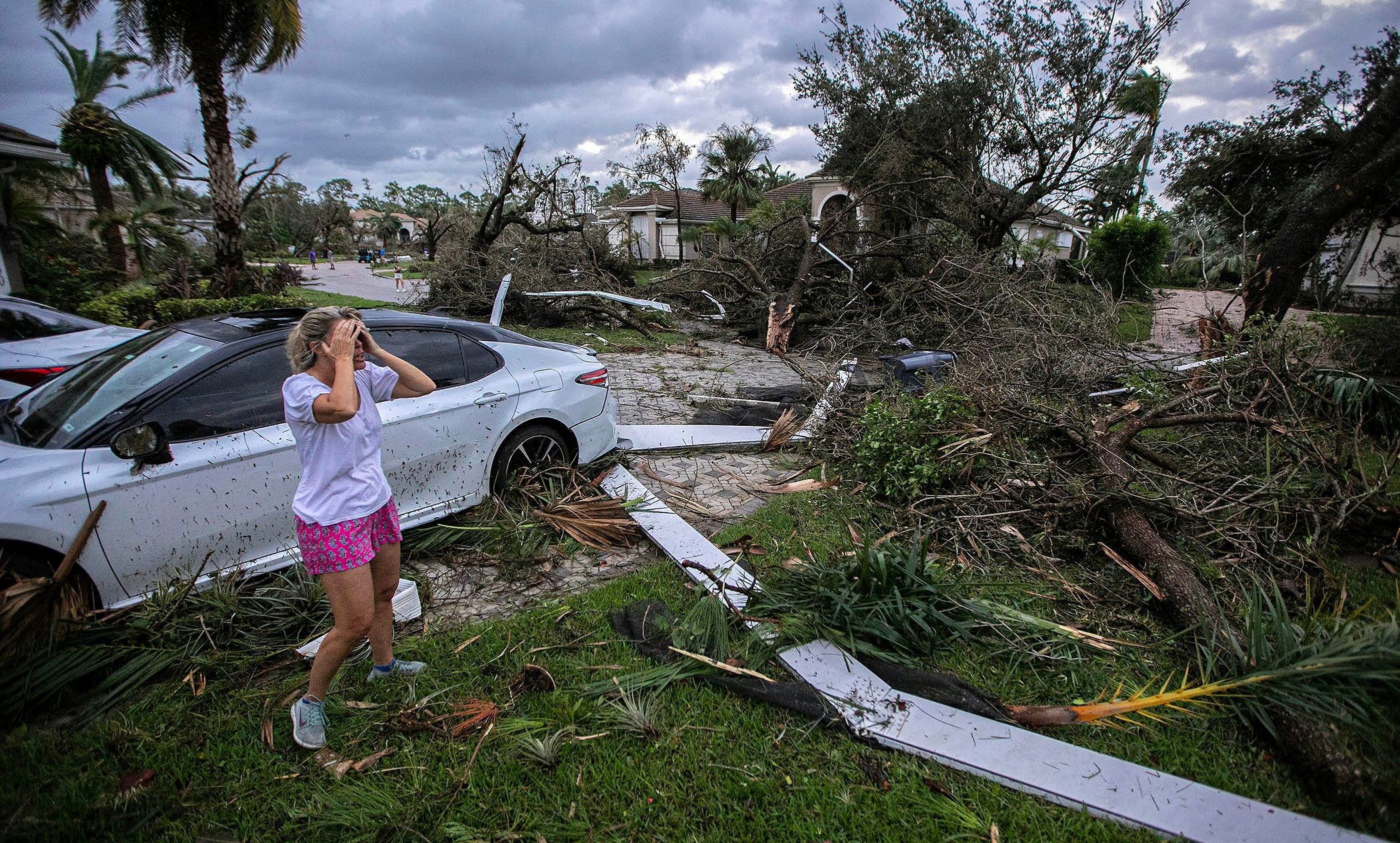 Marie Cook reacts to her damaged home after a tornado formed by Milton touched down in Wellington, Florida, on Wednesday.