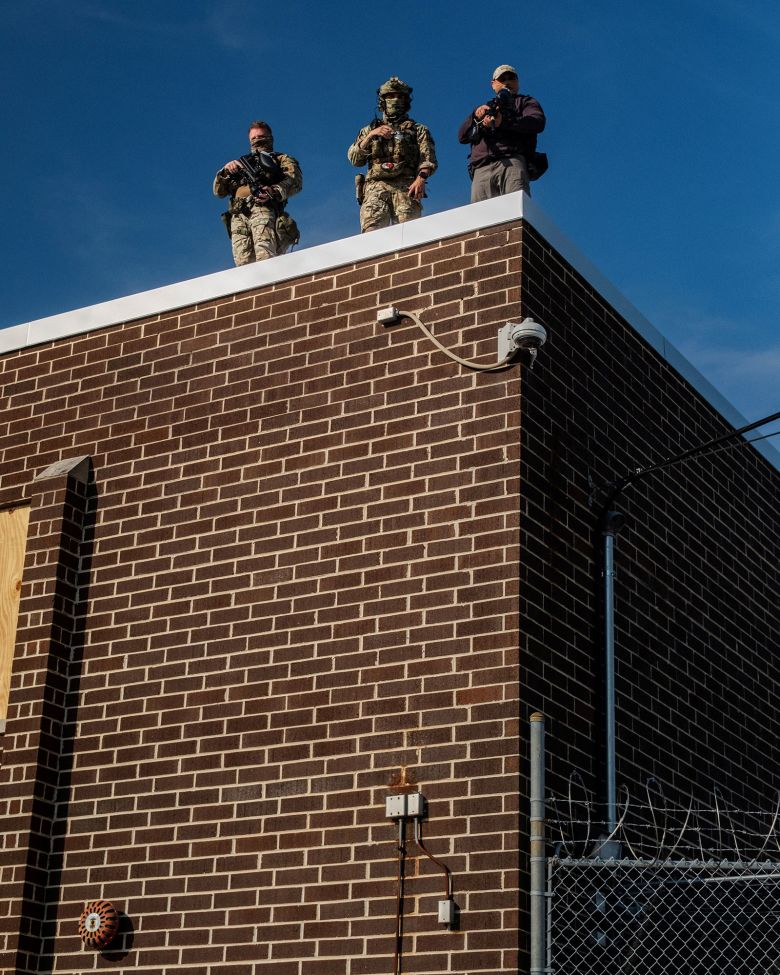Federal agents stand guard on top of the Broadview ICE facility, on September 19.