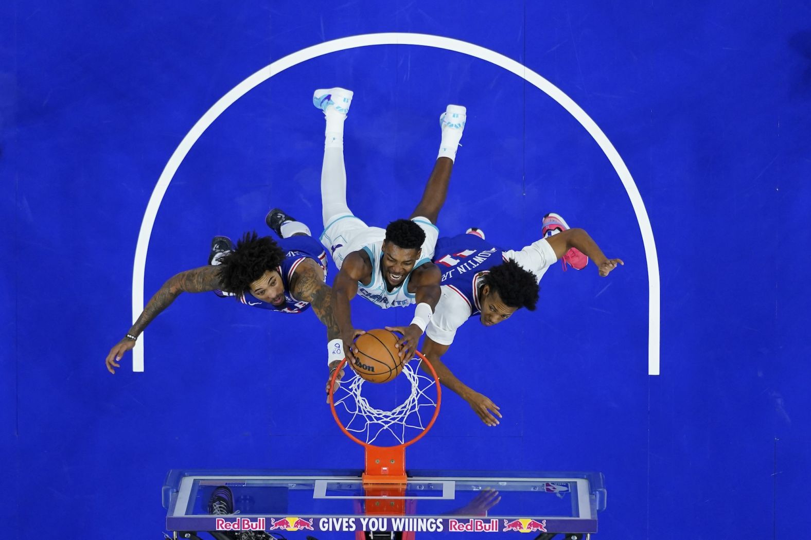 The Charlotte Hornets' Brandon Miller, center, dunks between Philadelphia 76ers Kelly Oubre Jr., left, and Jeff Dowtin Jr. during an NBA game in Philadelphia on Sunday, November 10.