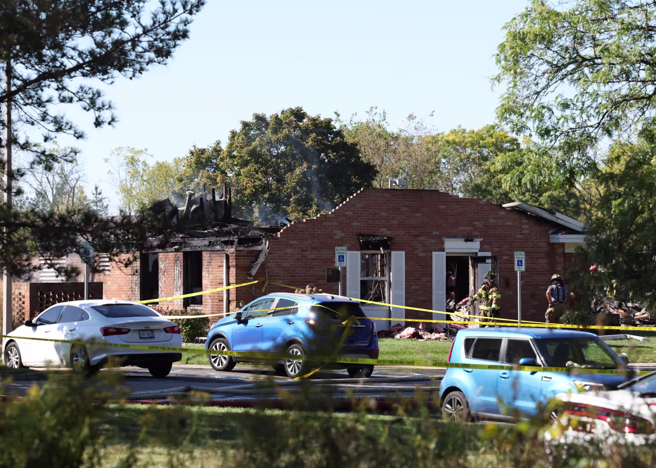 Fire and law enforcement officers stand outside the Church of Jesus Christ of Latter-day Saints after the fire was extinguished.