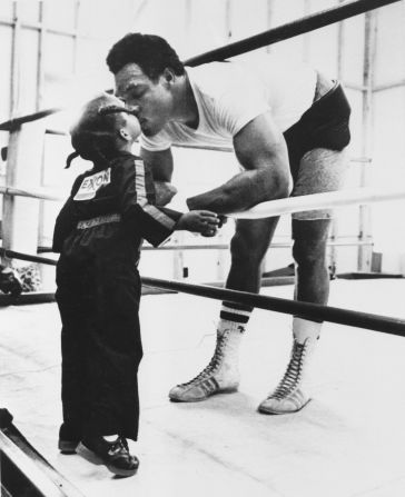 Foreman gets a kiss from his daughter Michi at a gym located on his farm in Marshall, Texas, in 1976.