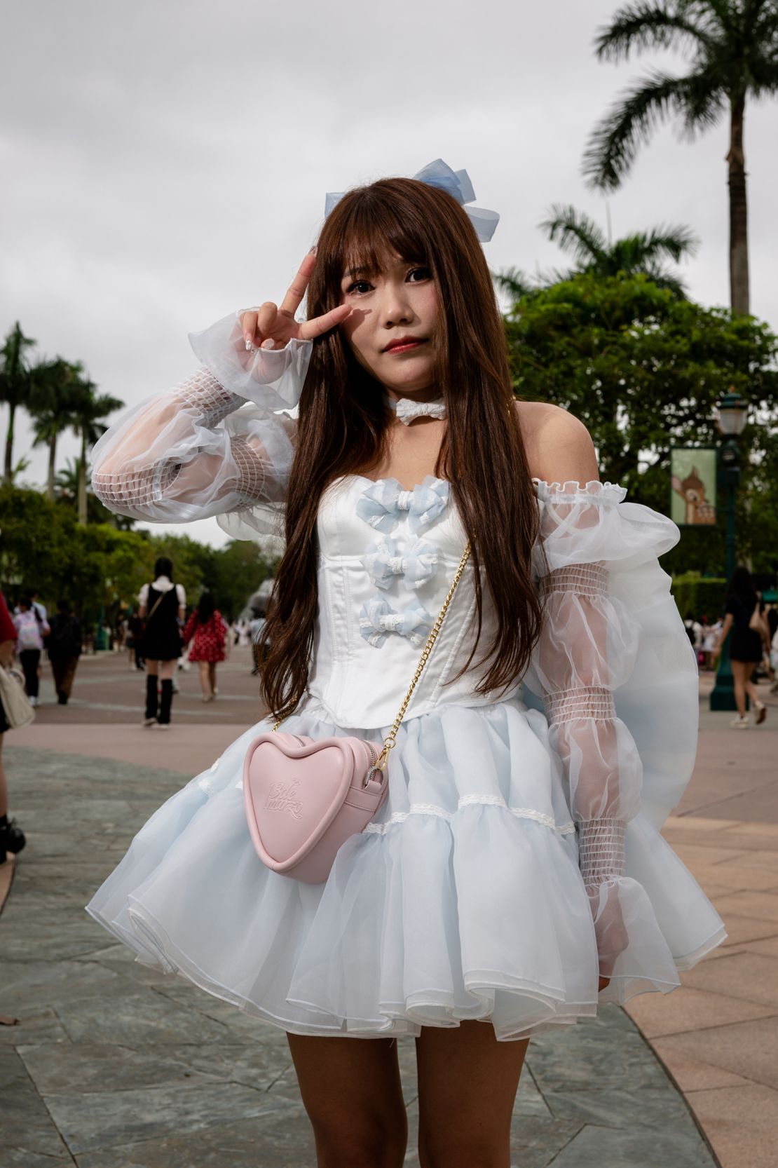 Li Mengru, 27, poses for a picture during an interview with CNN, at the entrance of Hong Kong Disneyland on June 7, 2024.