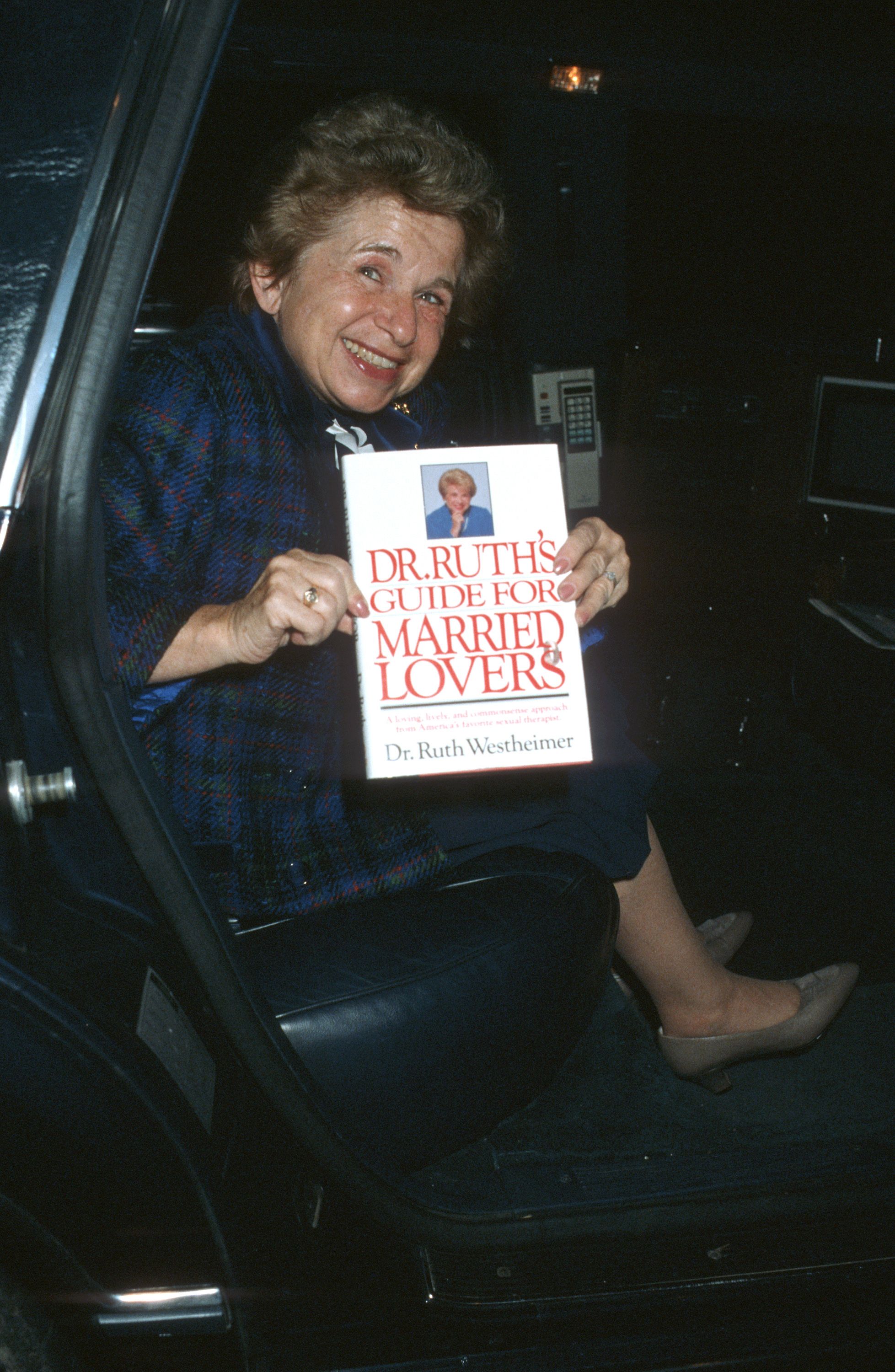 Westheimer holds a copy of one of her books in Beverly Hills, California, in 1986.