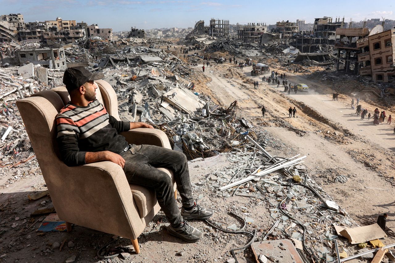 A man sits on a lounge chair atop a heavily-damaged building along Saftawi street in Jabalia in northern Gaza on Monday.