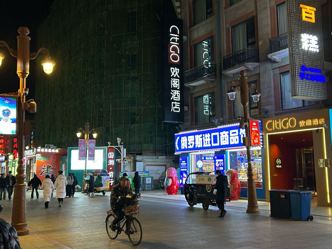 Residents pass by the "Russian Imported Goods Store" on a bustling shopping street in downtown Tianjin, China, on December 30.