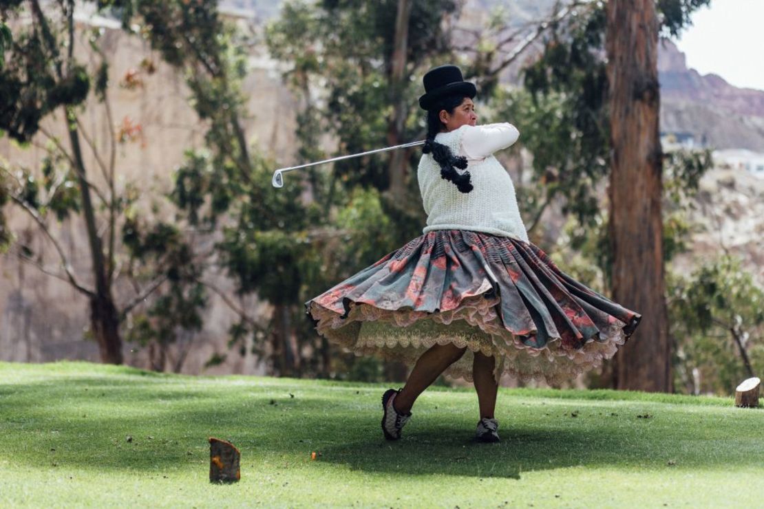 En La Paz, capital de Bolivia, una empleada de uno de los campos de golf más altos del mundo practica mientras viste la ropa tradicional boliviana.
