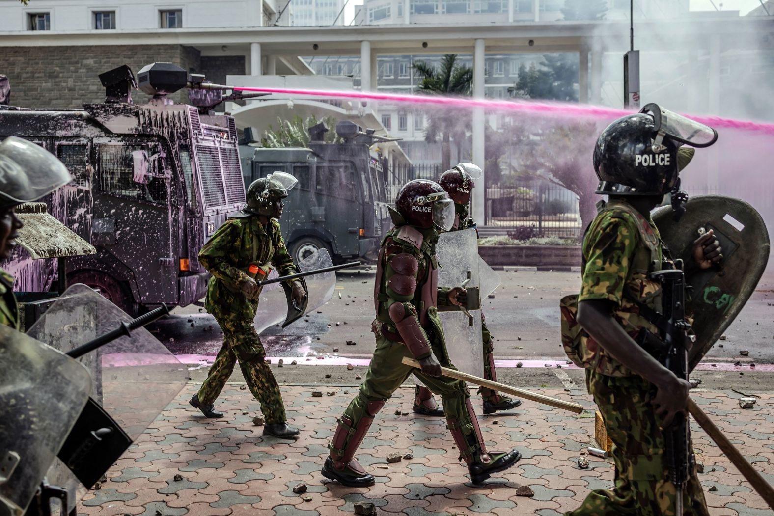 Police officers move in formation next to water cannon trucks as they clash with protesters in Nairobi, Kenya, on Tuesday, June 25. <a href="index.php?page=&url=https%3A%2F%2Fwww.cnn.com%2F2024%2F06%2F27%2Fafrica%2Fkenya-rocked-by-fresh-protests-intl%2Findex.html">A fresh wave of demonstrations swept the country on Thursday</a> despite President William Ruto’s U-turn on controversial tax plans.