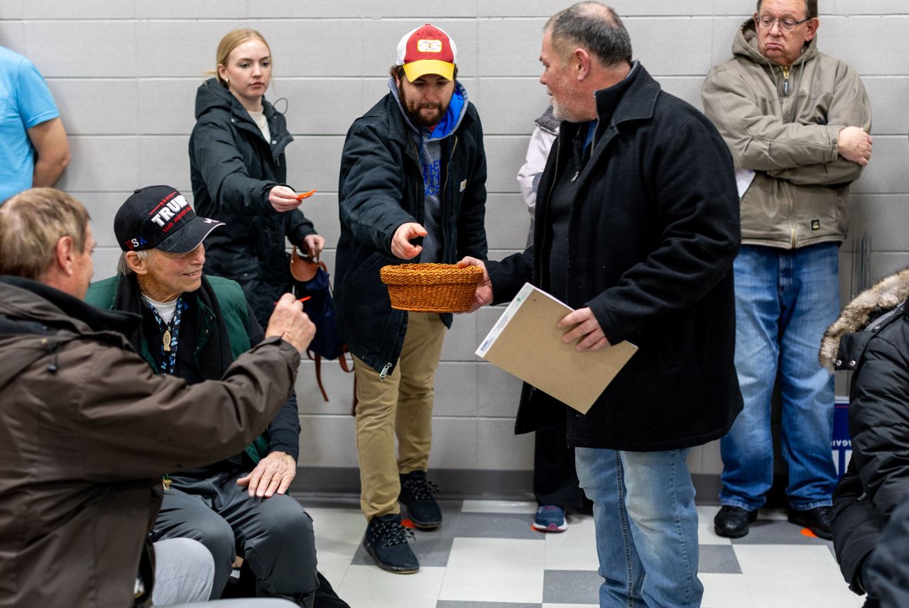 Pink slips of paper are collected in a wicker basket to tally the votes on caucus night at Mitchell Elementary on Monday in Ames, Iowa. 