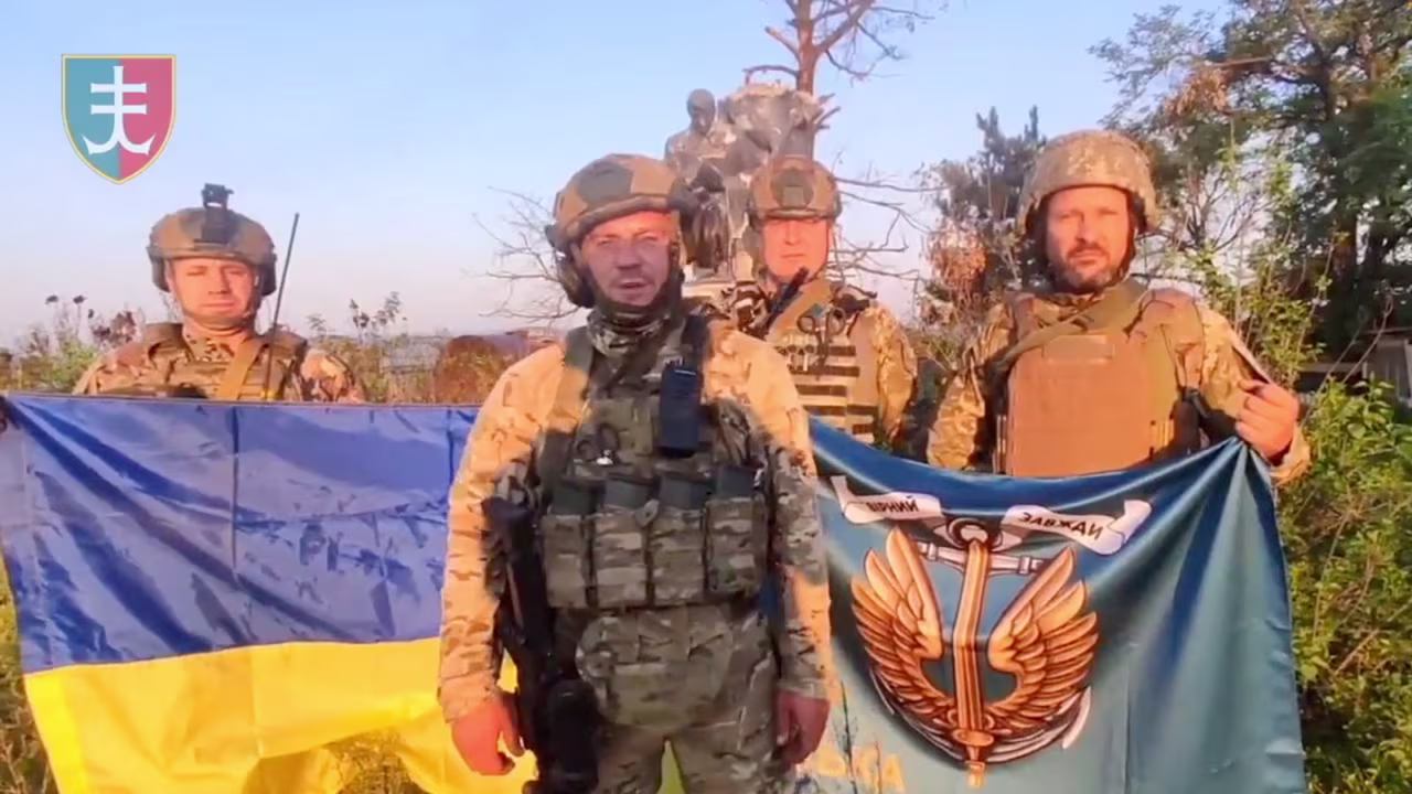 Ukrainian soldiers stand with Ukrainian flag in Urozhaine, Donetsk Region, Ukraine, in this screen grab obtained from a handout video released on August 16.