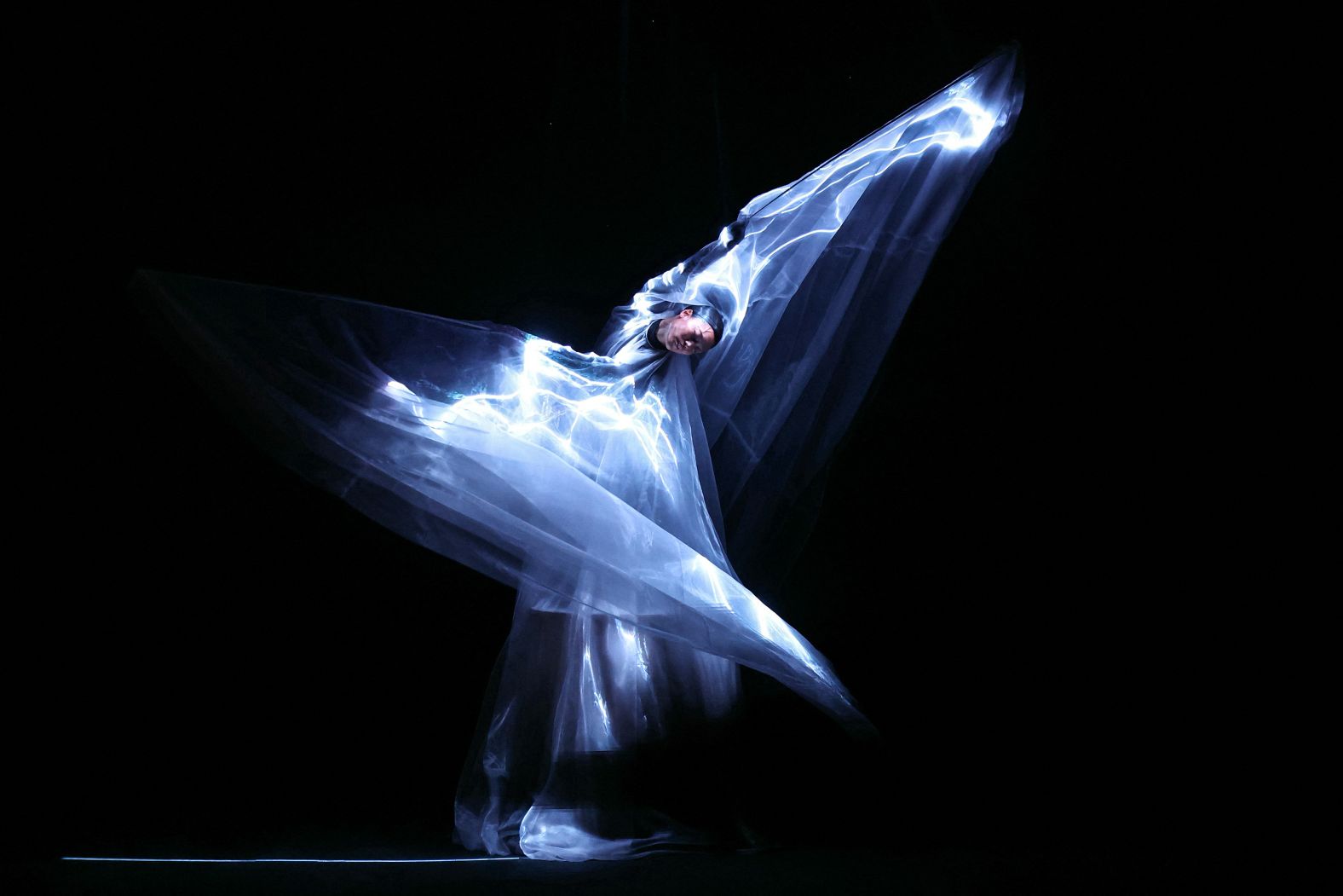 A performer wears a glowing dress <a href="index.php?page=&url=https%3A%2F%2Fwww.youtube.com%2Fwatch%3Fv%3DG7DACzFerqA" target="_blank">made from bioluminescent algae</a> during an Iris Van Herpen fashion show in Paris on Monday, July 7.