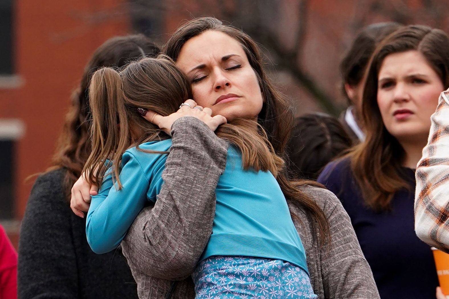 Rachel Sambrano holds her daughter Ariah at a prayer vigil in Wichita, Kansas, on Thursday. The plane that collided with the helicopter had originated in Wichita.