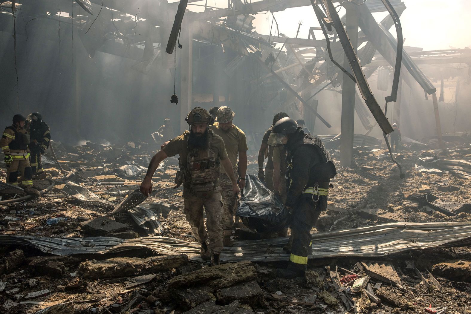 Emergency rescue personnel and military members carry a body of a victim who died following a Russian strike on a supermarket in Kostyantynivka, Ukraine, on Friday, August 9.