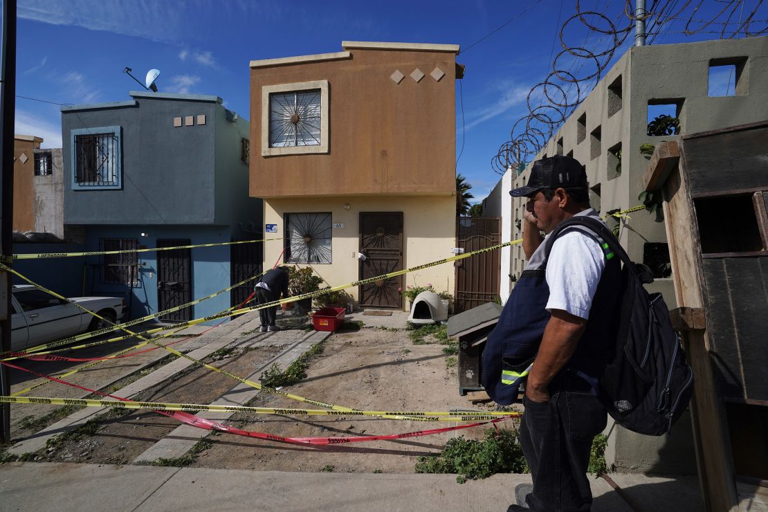 Xochitl Zamora, a friend of murdered journalist Lourdes Maldonado, collects her friend's pets from the crime scene and Maldonado´s home, as a security guard looks on, in Tijuana, Mexico, Tuesday, Jan. 25, 2022.