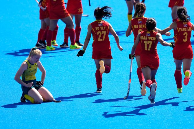 Australia's Amy Lawton reacts as Chinese field hockey players celebrate their quarterfinal win on August 5.