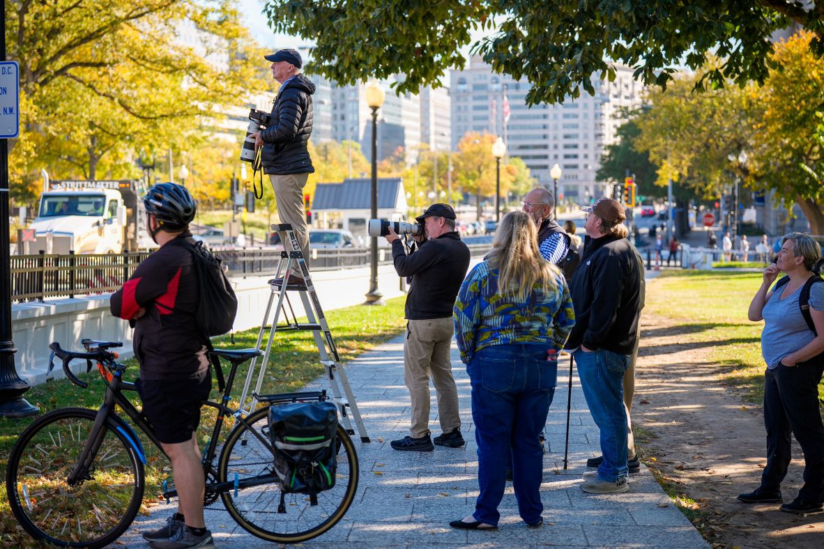 Photographers and pedestrians stop to watch the facade being demolished on October 21.