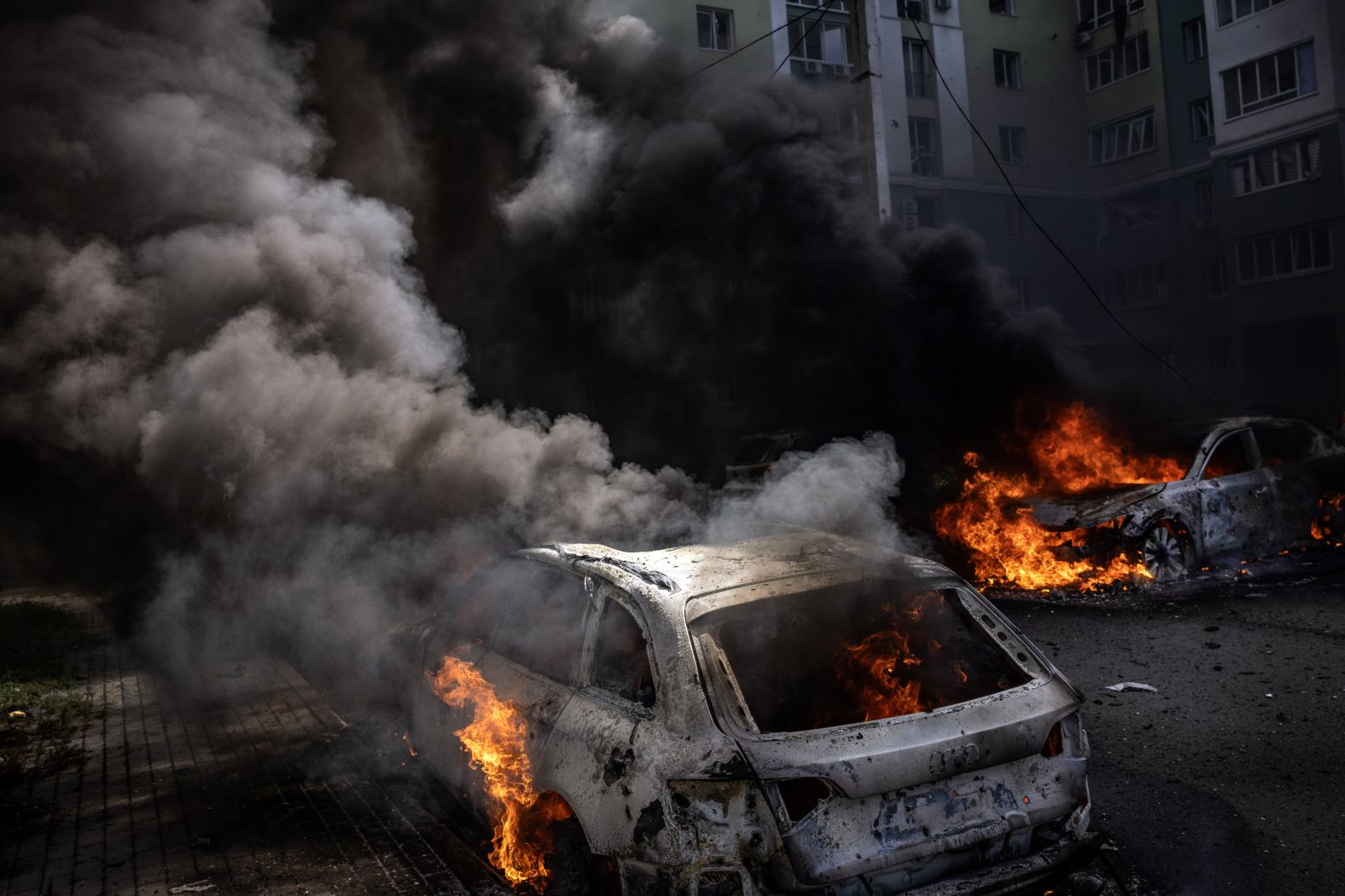 Cars burn in a parking lot following a Russian bomb attack on an apartment building in Kharkiv, Ukraine, on Thursday, July 24.