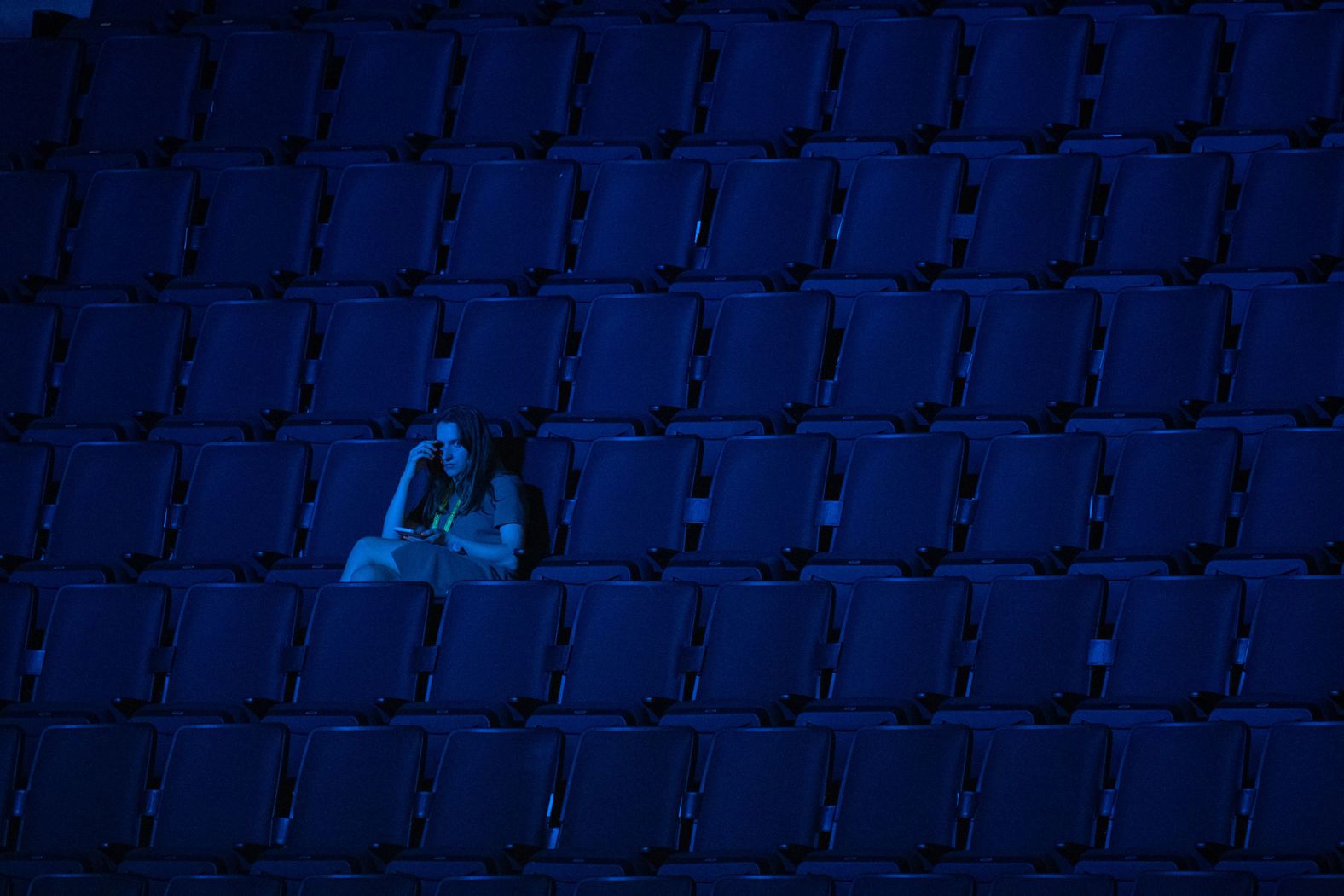 A woman sits in a section of the arena before the night's speeches on Tuesday.