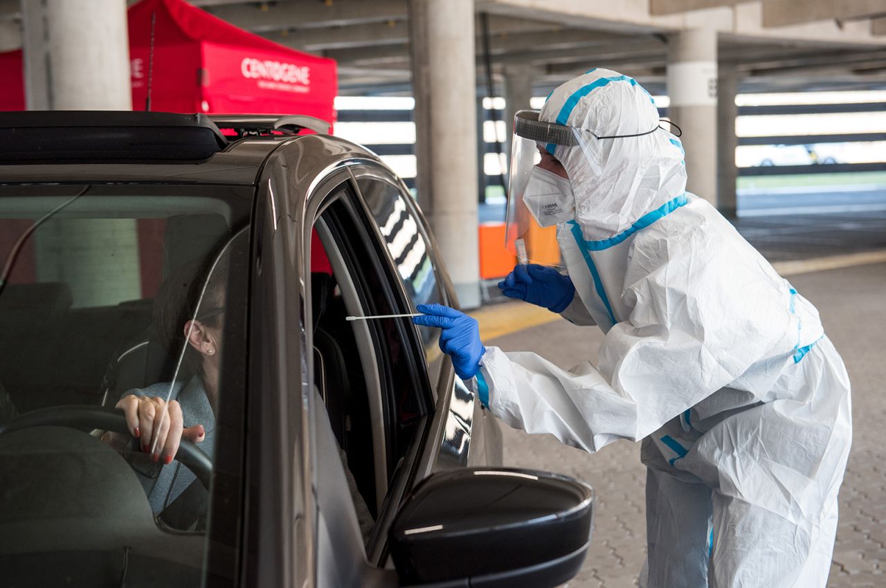 An employee takes a swab from a woman for a Covid-19 test during a trial run for a drive-through Covid-19 testing center at the airport in Hamburg, Germany, on March 31.