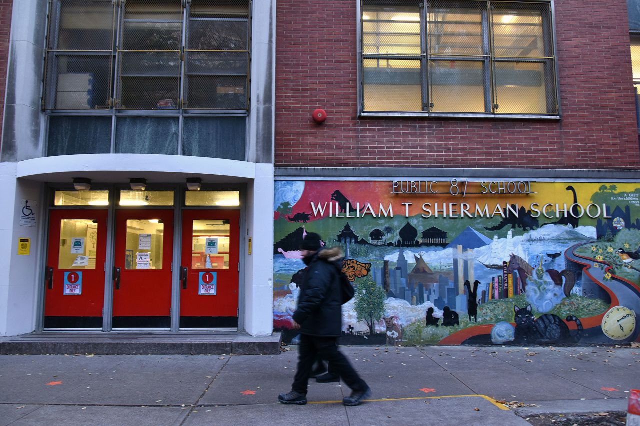 People walk past a public school in New York on November 18.