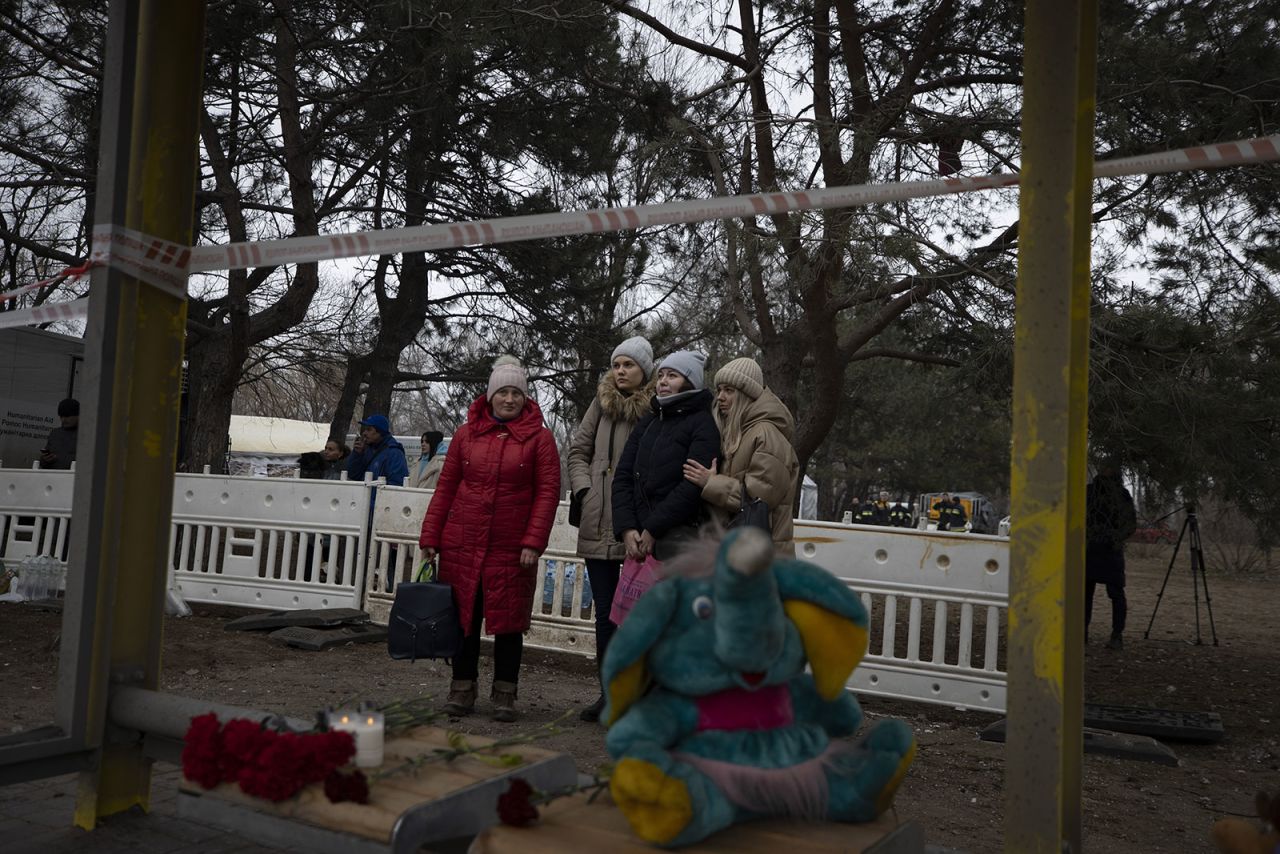 Relatives of victims stand together at a makeshift memorial near the site of Saturday’s attack on an apartment building in Dnipro, Ukraine.