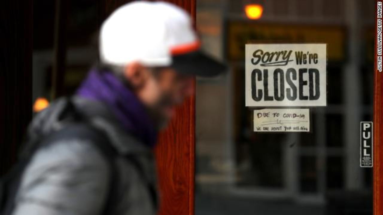 A pedestrian walks by a 'closed' sign on the door of a restaurant on March 17, in San Francisco, California.