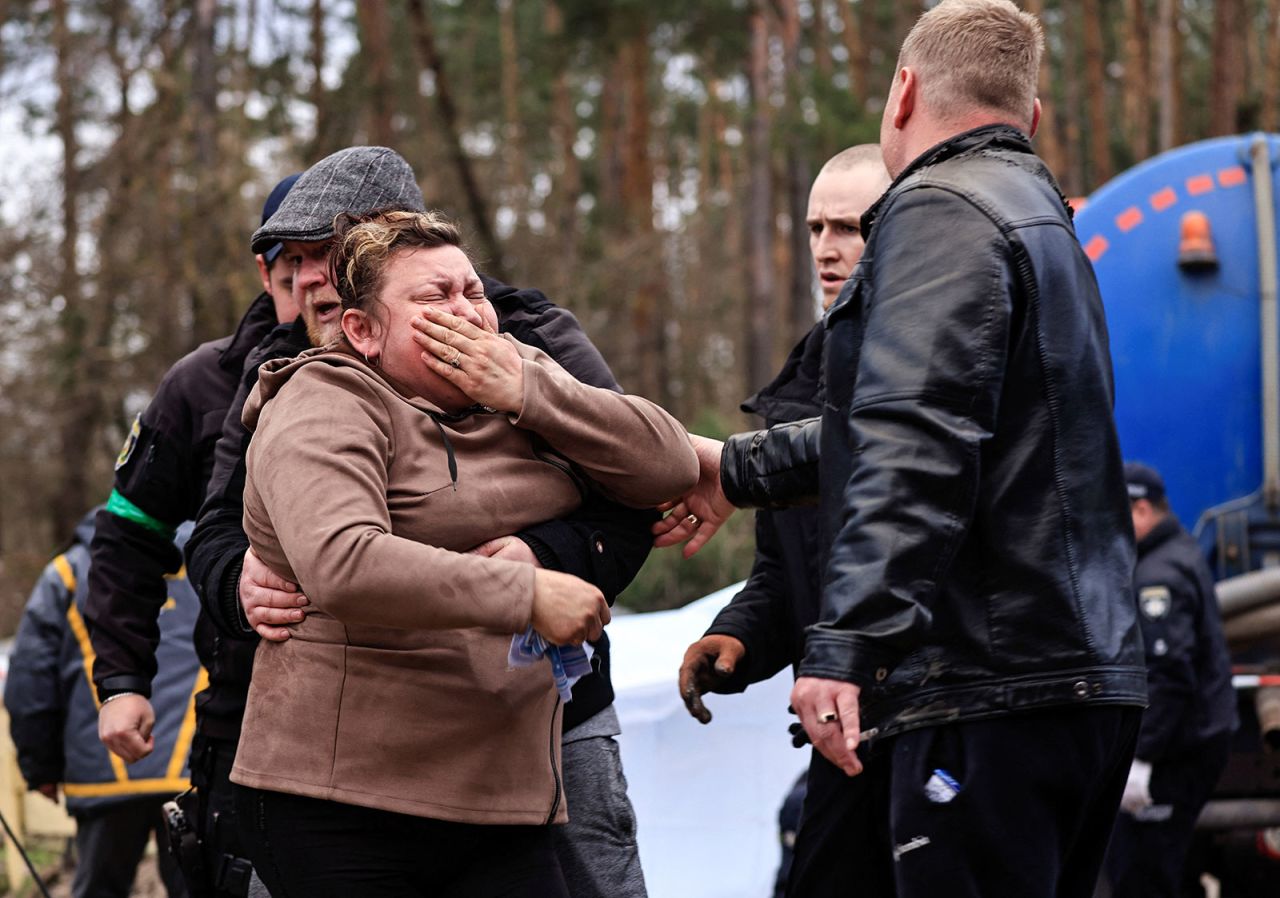 A mother reacts as police members exhume the body of her son from a well in the town of Buzova, Ukraine, on April 10.