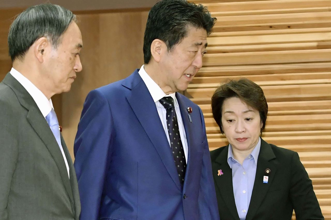 Japanese Prime Minister Shinzo Abe, center, walks past Olympic Minister Seiko Hashimoto, right, to attend a cabinet meeting at his official residence in Tokyo on Tuesday, March 24.