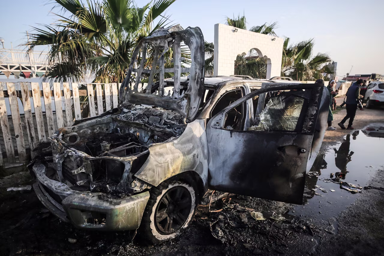 Palestinians stand next to a vehicle in Deir Al-Balah, Gaza, on April 2, where employees from the World Central Kitchen were killed in an Israeli airstrike.