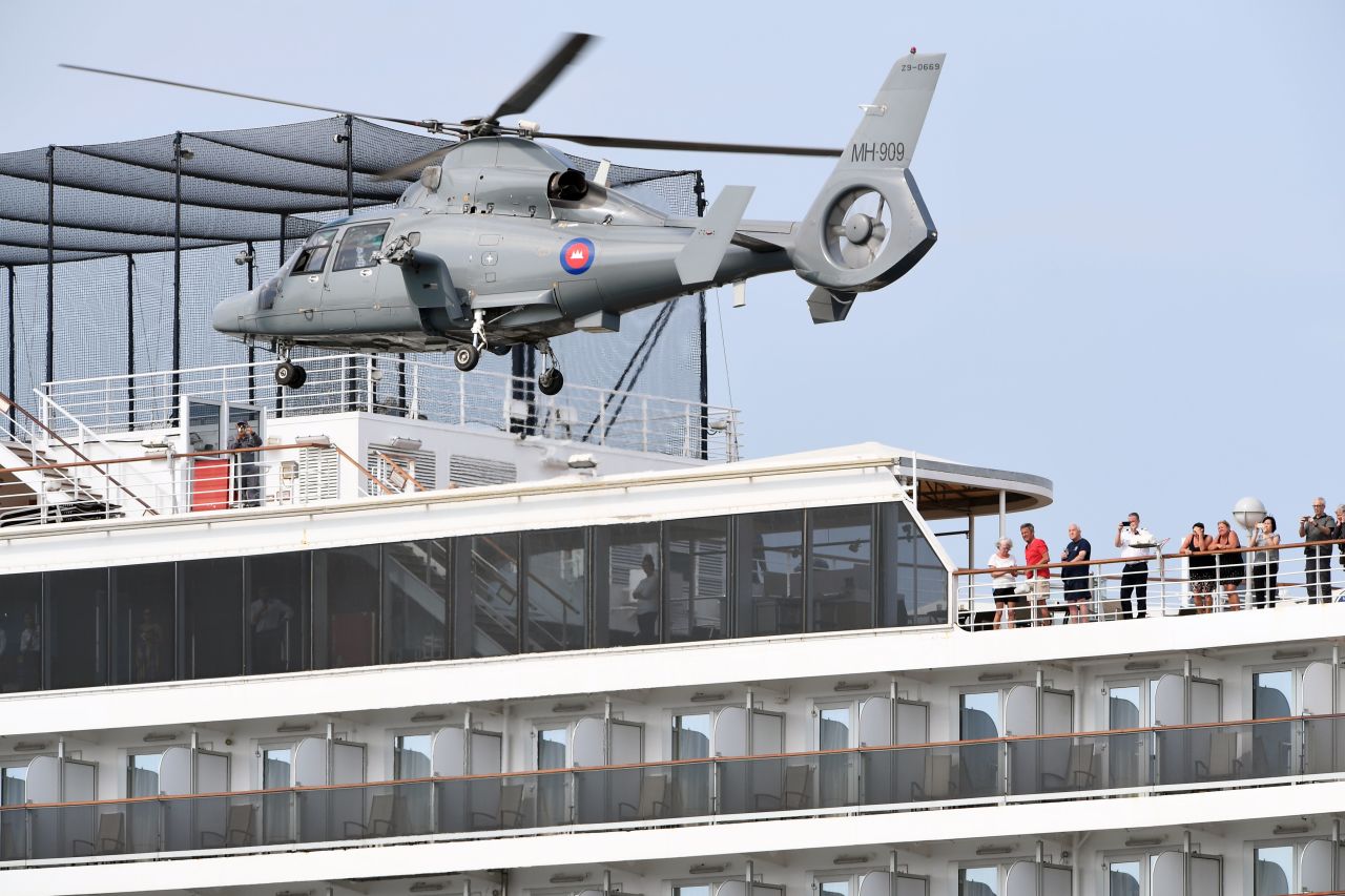 People on a deck of the Westerdam cruise ship watch a helicopter take off in Sihanoukville.