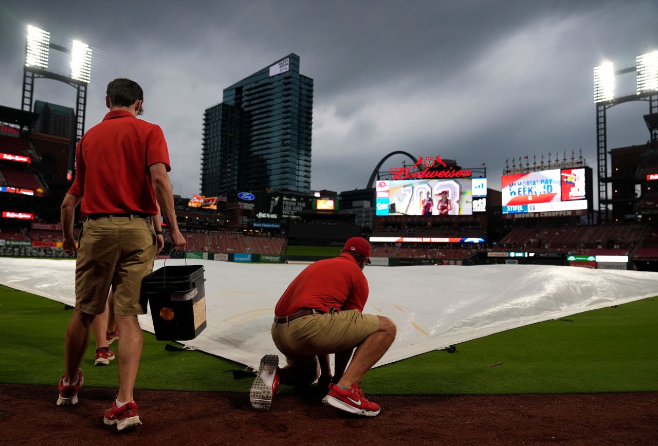 Members of the Busch Stadium grounds crew place a tarp over the field ahead of the game between the St. Louis Cardinals and the Chicago Cubs on May 26 in St. Louis. 