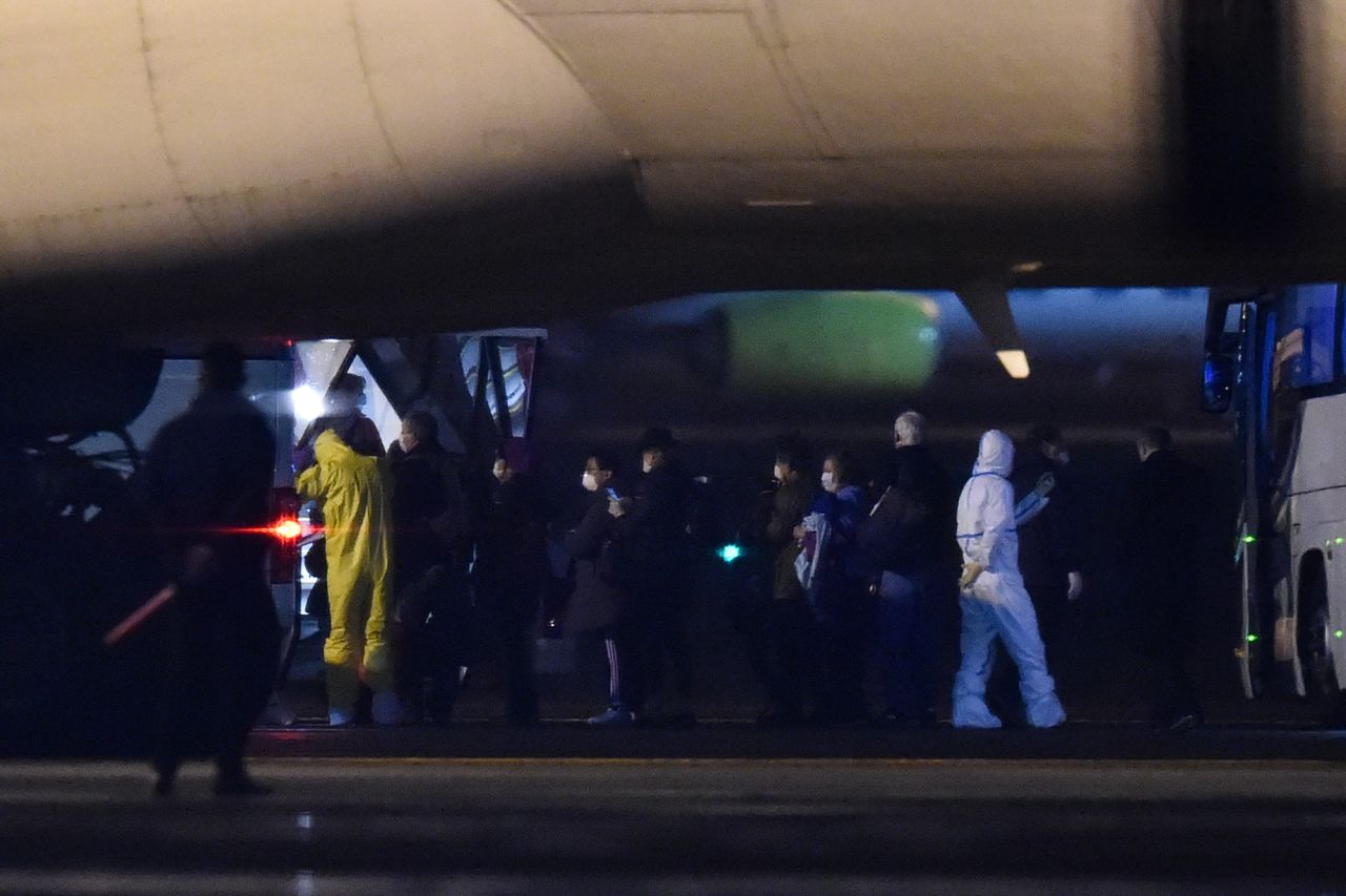 US passengers queue to enter in a plane at the Haneda Airport, in Tokyo on February 17 after disembarking in Yokohama from the Diamond Princess cruise ship.