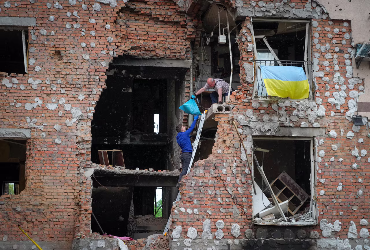 Residents take out their belongings from their house ruined by the Russian shelling in Irpin, Ukraine, on Saturday, May 21.