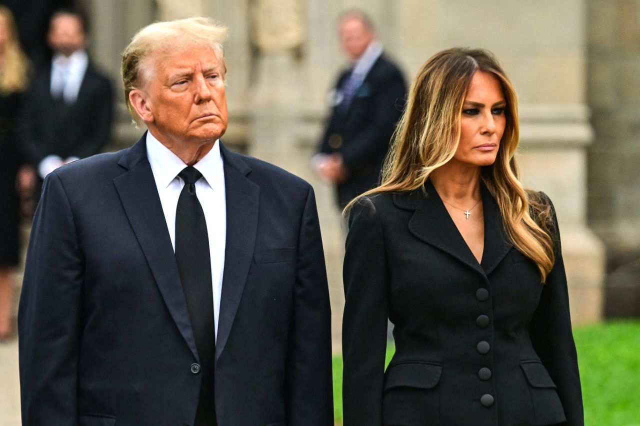 Former President Donald Trump stands with his wife Melania Trump as they depart her mother’s funeral in Palm Beach, Florida, on January 18. 