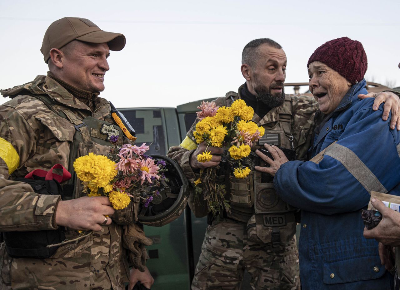 A resident welcomes Ukrainian soldiers with flowers as the Ukrainian military enters the southern city of Kherson, Ukraine on November 12. 