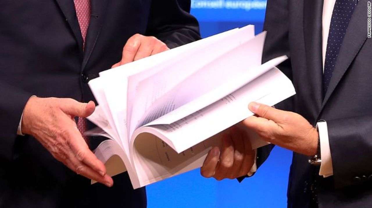 EU chief Brexit negotiator Michel Barnier, left, and European Council President Donald Tusk flip through the pages of a draft withdrawal agreement in Brussels on Thursday. (AP Photo/Francisco Seco)