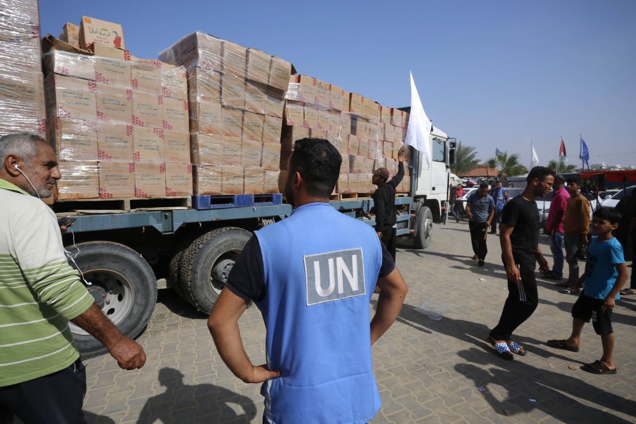 Palestinians are served food by UNRWA officials in Khan Younis, Gaza, on Tuesday.