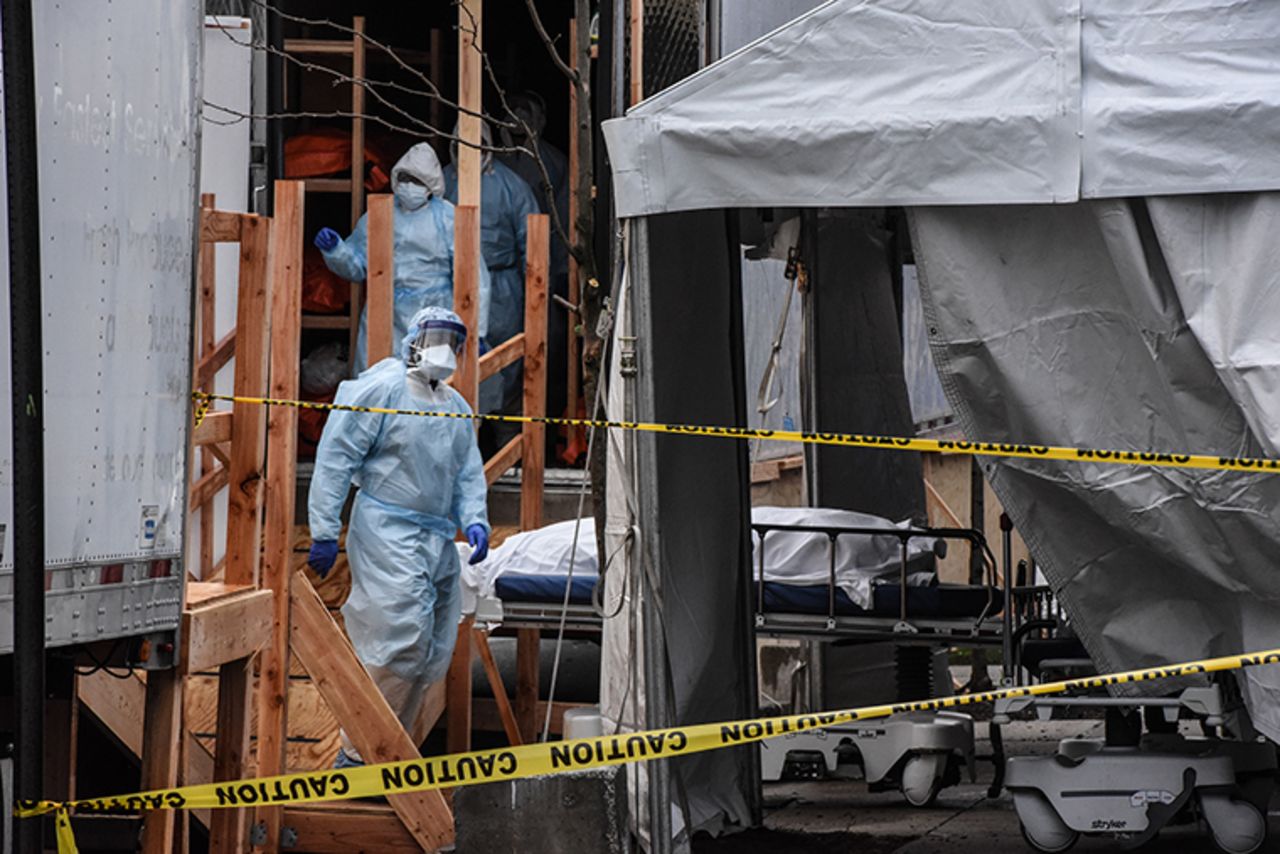 Medical workers move a body from the sidewalk into a refrigerator truck outside of Wyckoff Heights Medical Center in the borough of Brooklyn on Friday, April 3,  in New York City. 