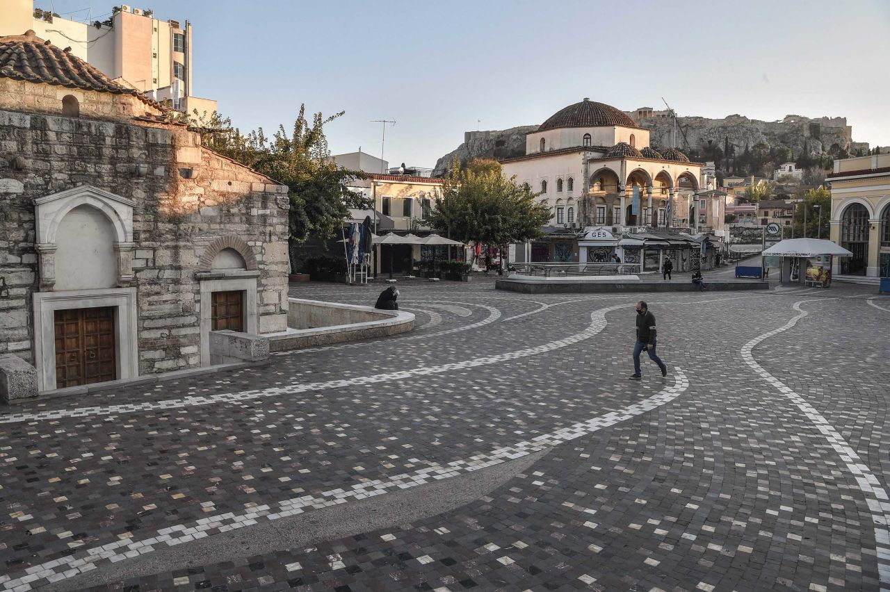 A person walks past a nearly empty square in Athens, Greece, on December 1.