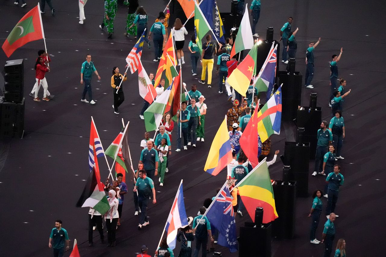 Athletes carry flags at the Stade de France. 