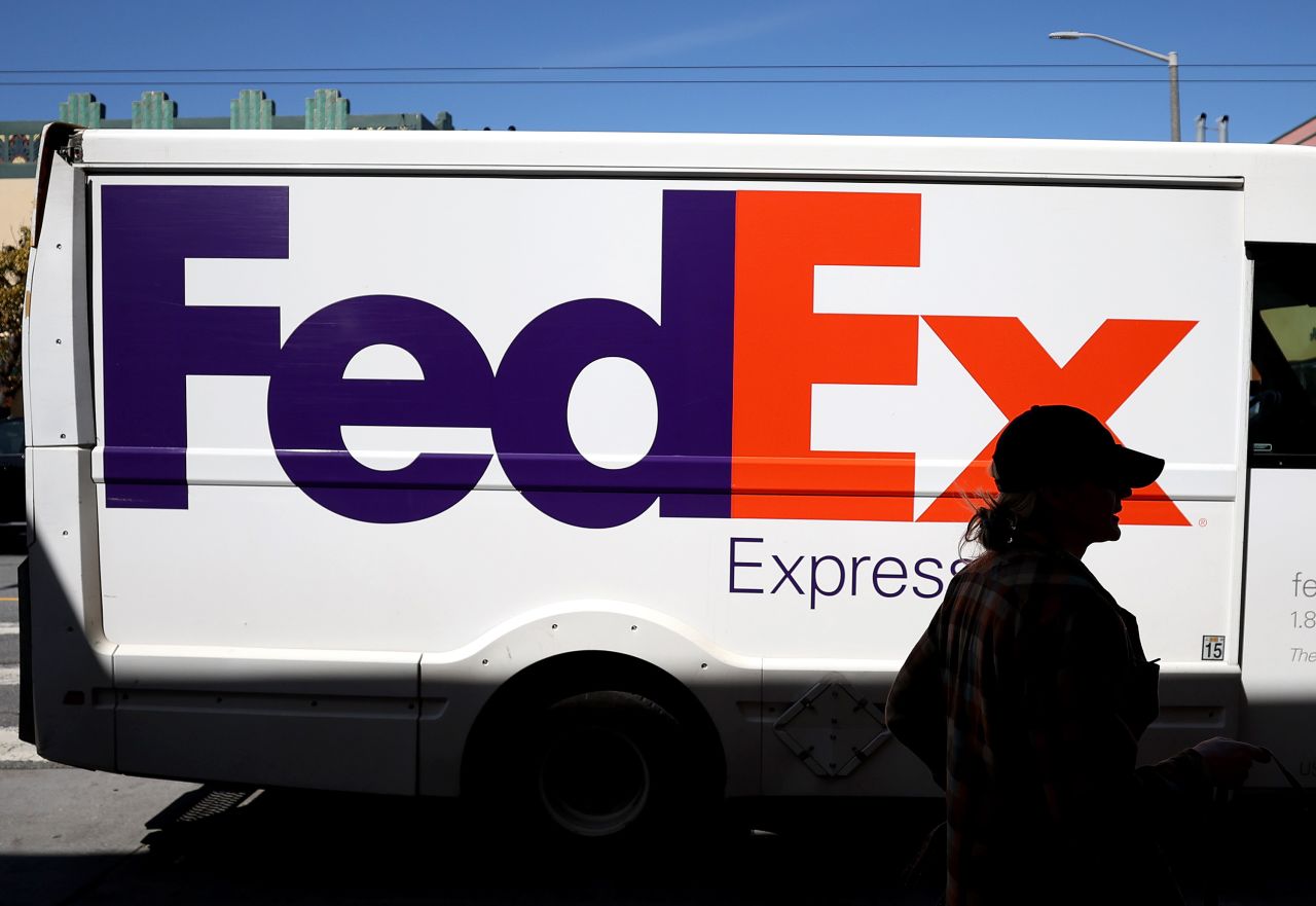 A person walks by a FedEx delivery truck in San Francisco on March 21.